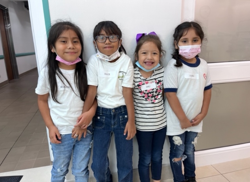 Four young IMA School students smiling side by side after their dental appointment