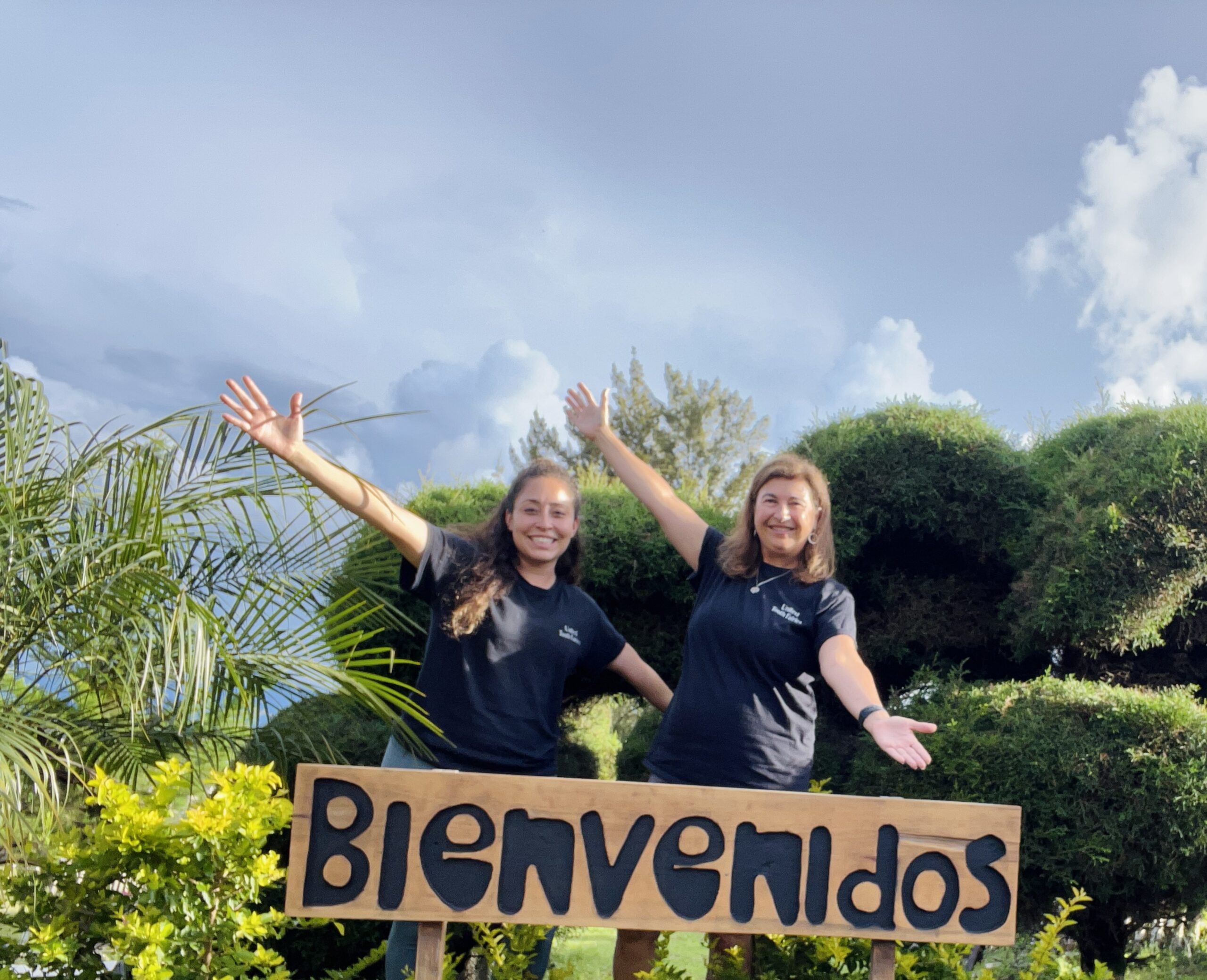 United Tooth Fairies founders Roberta Schuller and Jolie Rowell beside a Bienvenidos sign in Guatemala